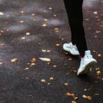 Faceless person running on dark pavement