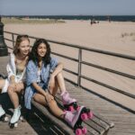 Girls in Rollers Sitting on Bench on Beach