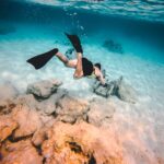 person wearing diving suit underwater shallow focus photography