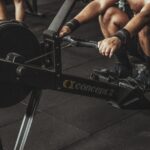 topless man using rowing machine