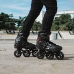 person in black leather boots riding black motorcycle during daytime