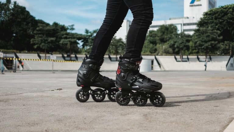 person in black leather boots riding black motorcycle during daytime